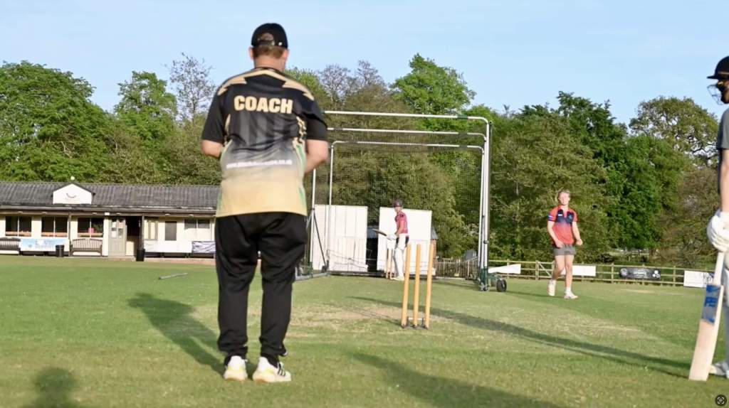 Cricket coach mentoring players during an outdoor net session, supporting coach development at Cricket Mind Online